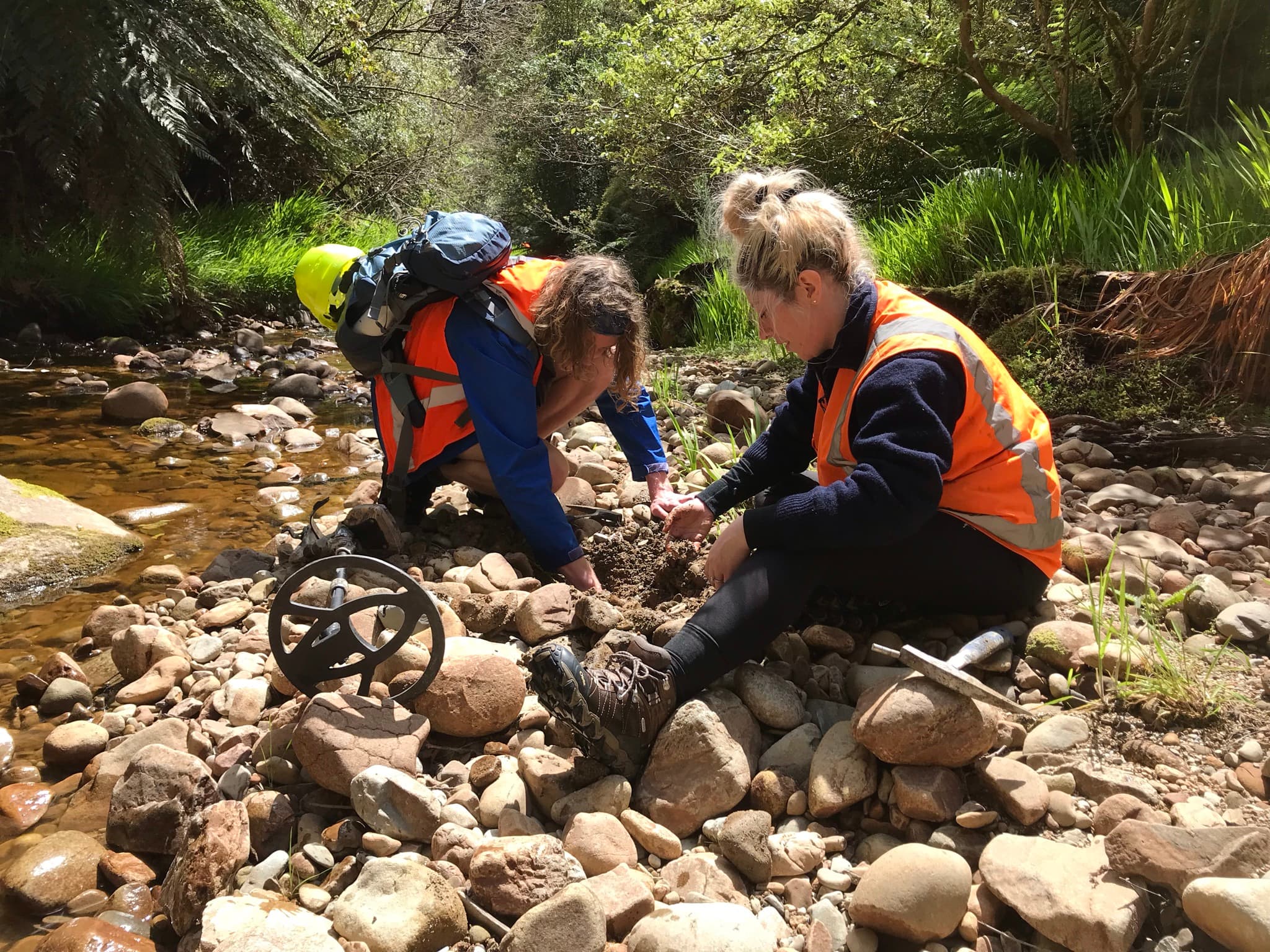 Daniel Burgin and Eve Aitken dig through the stones by the stream bed.