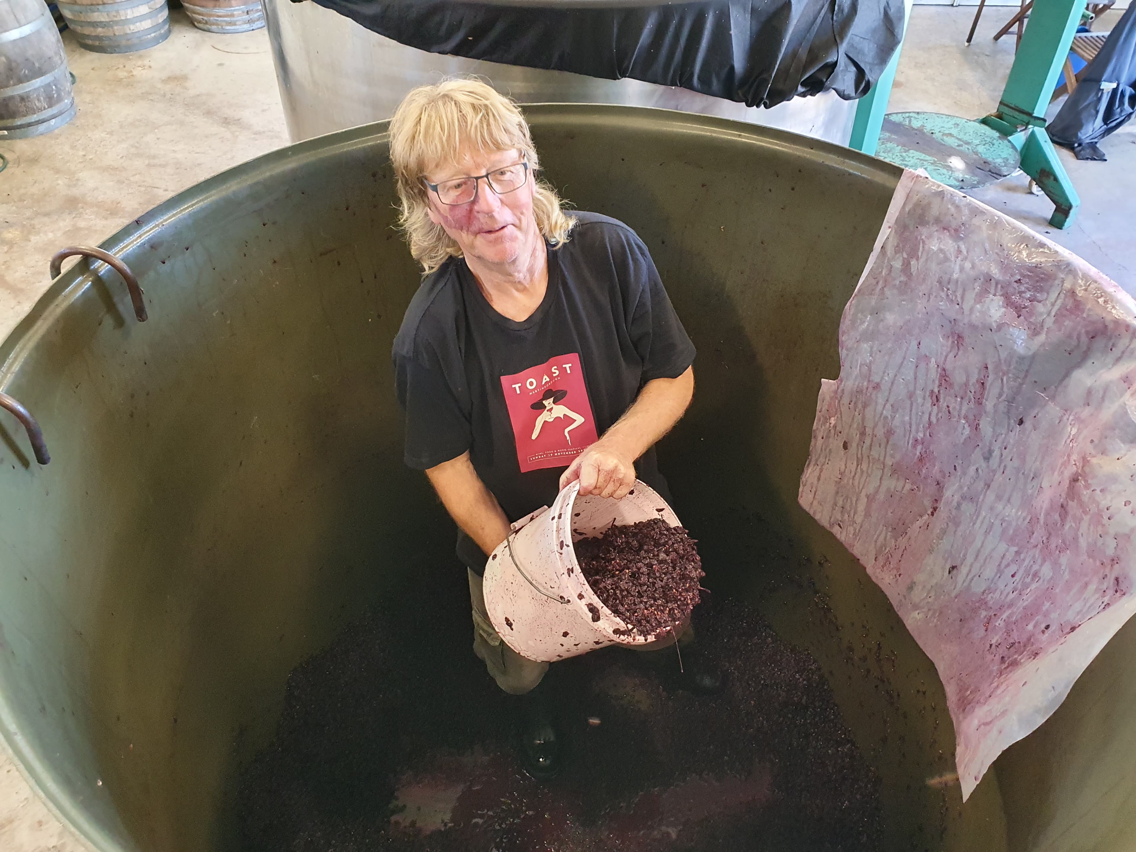 John Douglas scrapes a tank clean of skins during the 2020 vintage