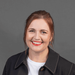 Smiling portrait of Charlotte Ryan on grey background