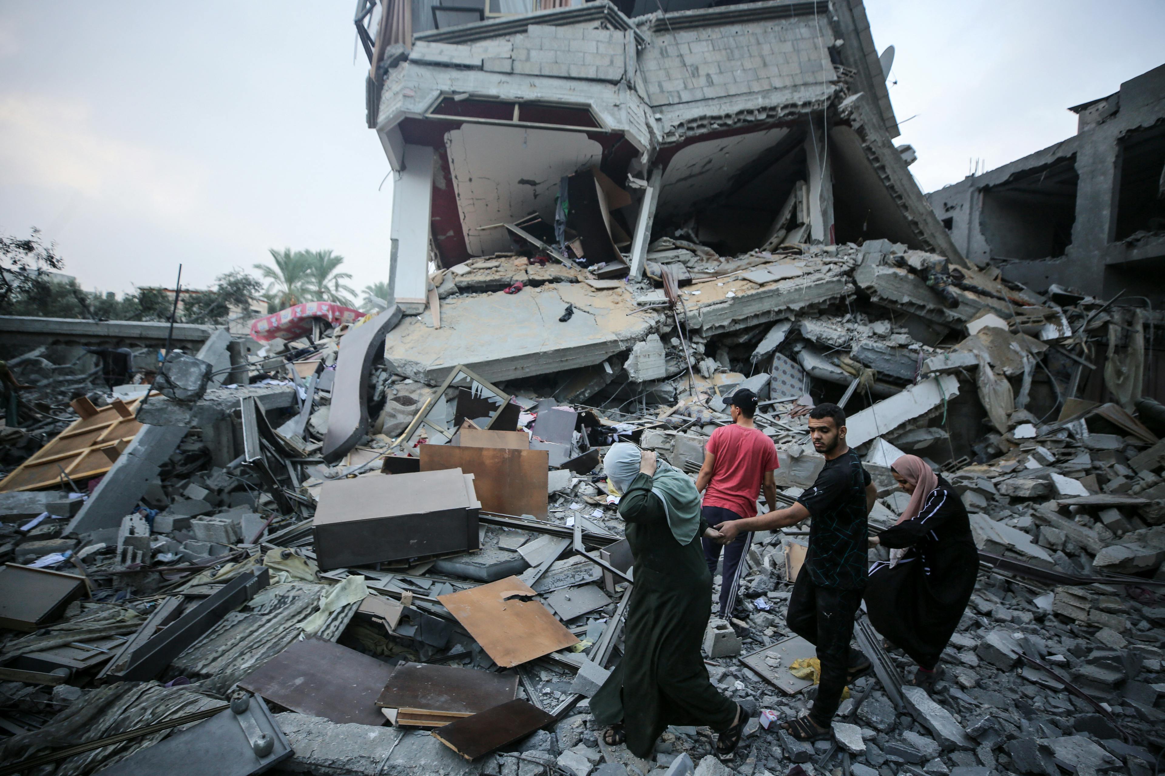 Palestinians gather at the site of Israeli strikes on houses in Deir Balah in the central Gaza Strip, on October 24, 2023, during ongoing battles between Israel and the Palestinian Hamas group.