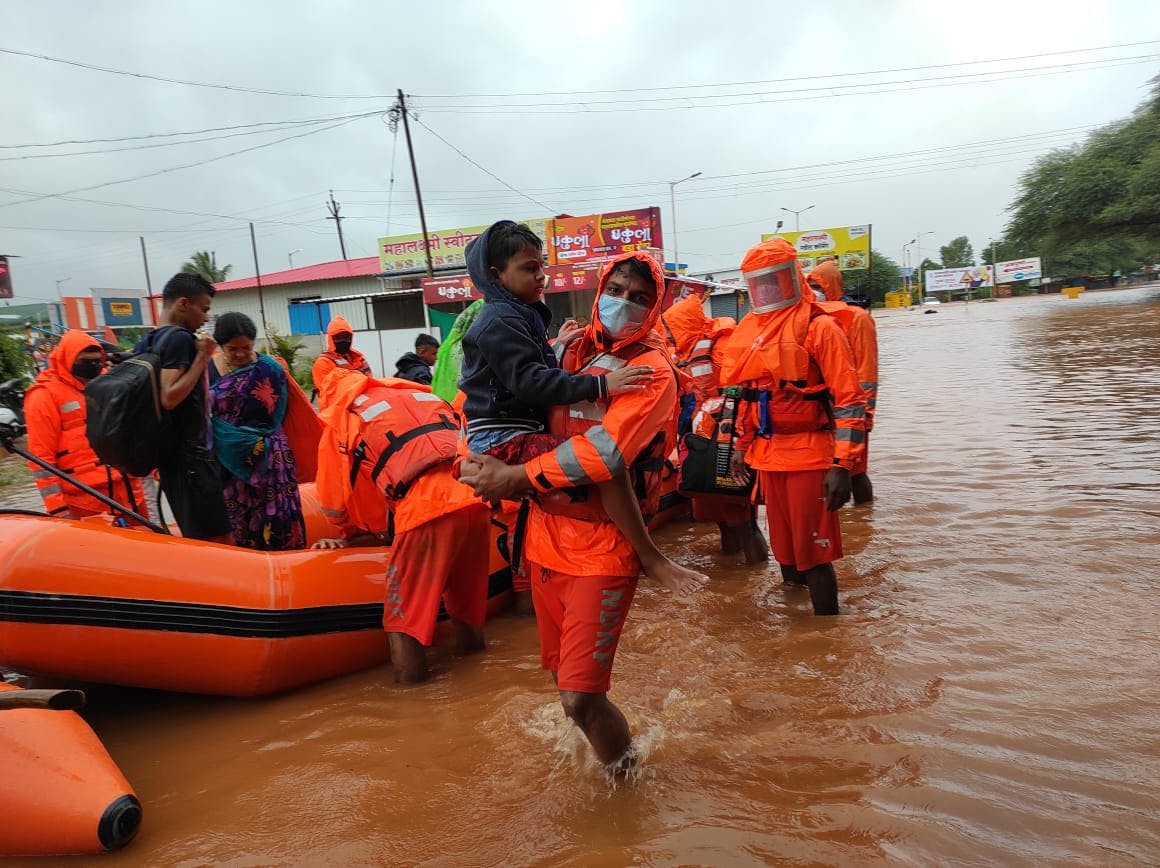 Rescuers, shown here in Kolhapur,  have been using boats to ferry people to safety, but have been hampered by downpours.