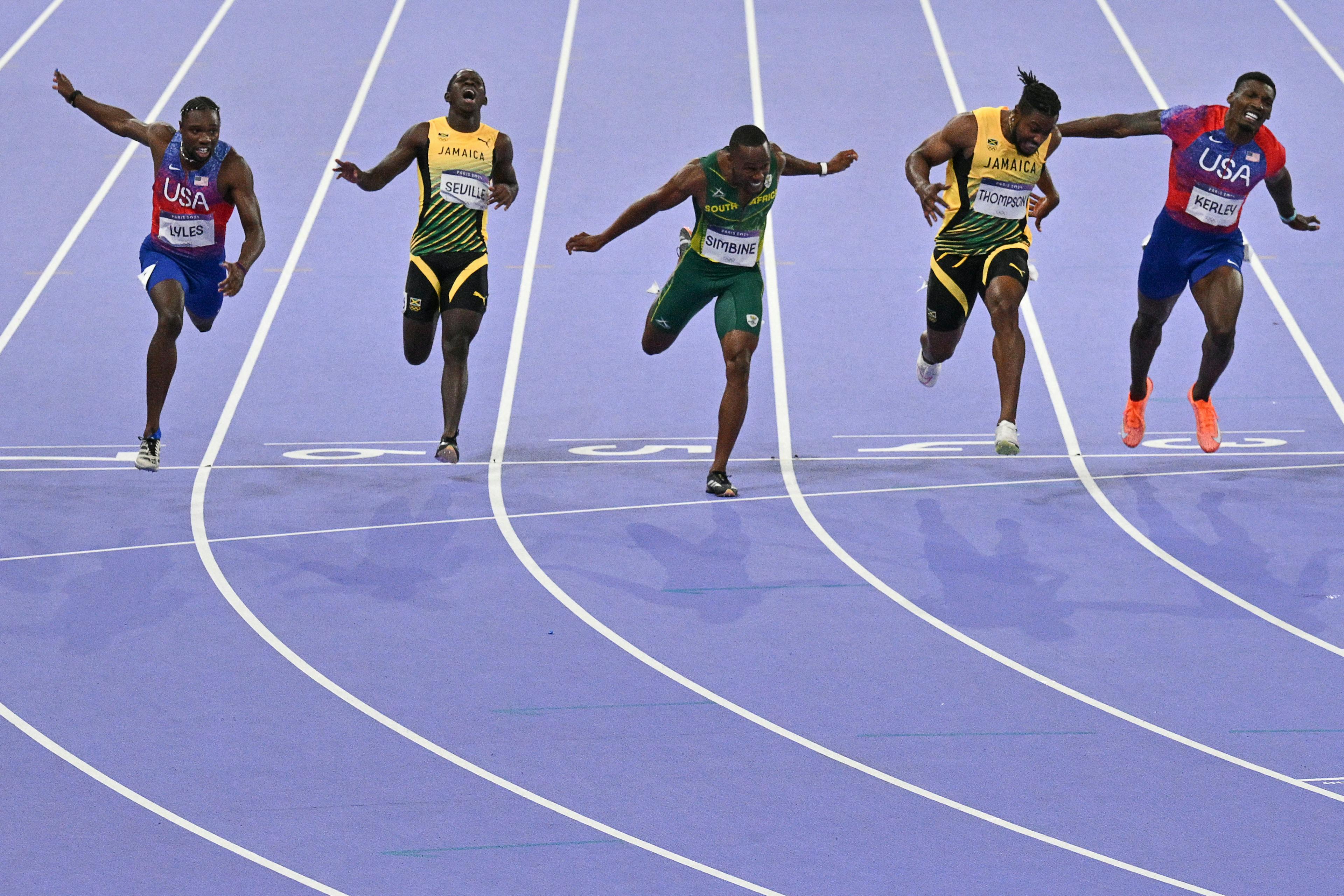 Winner Noah Lyles (L) of the United States crosses the finish line ahead of Jamaica's Kishane Thompson (2R), US' Fred Kerley (R) in the Paris Olympics men 100m final.