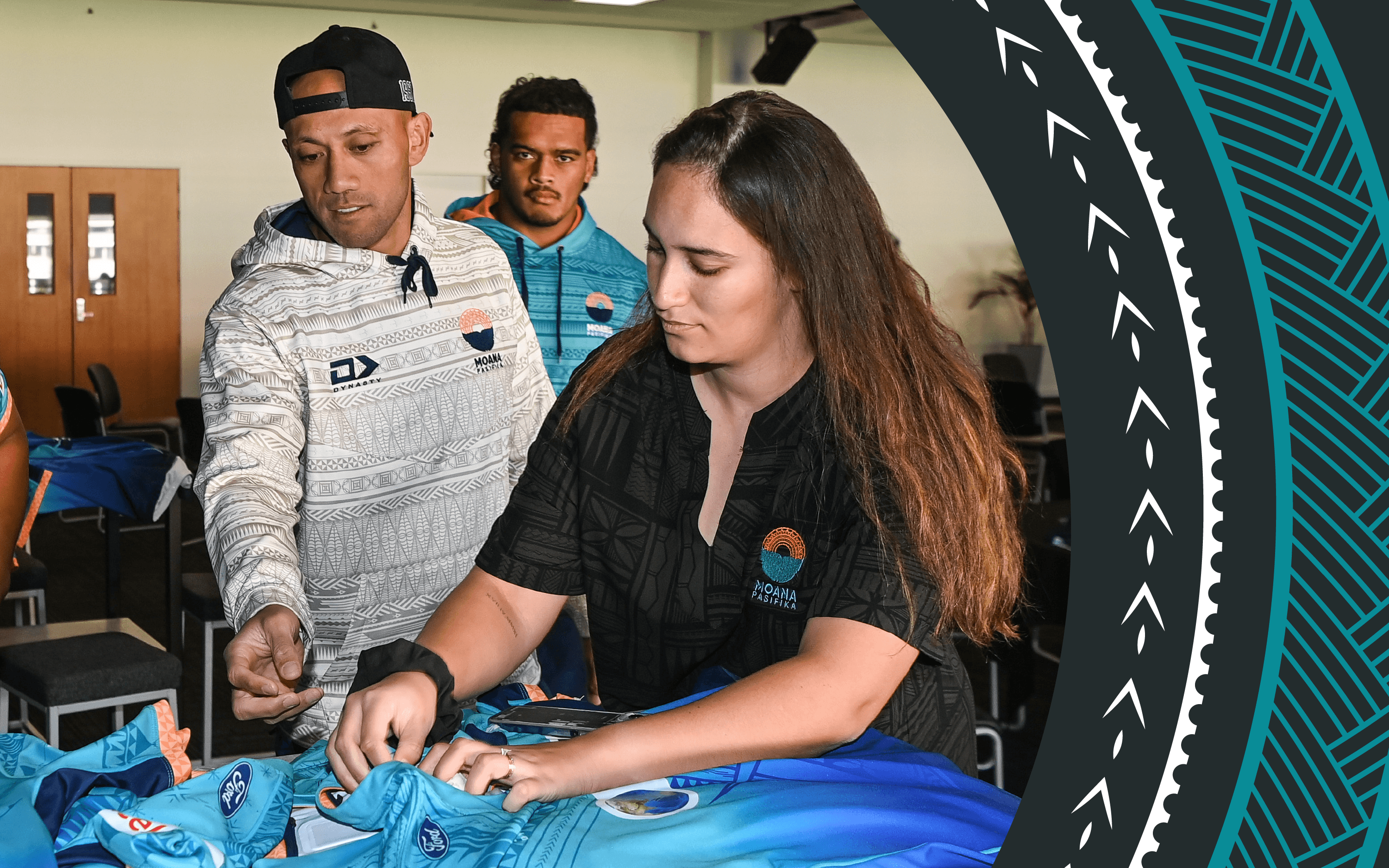 A photo of Ereatara Enari, Christian Leali'ifano and Taylah Johnson looking at the blue Moana Pasifika uniform during a team photo session at Mt Smart Stadium, Auckland, New Zealand on Friday 27 May
2022.