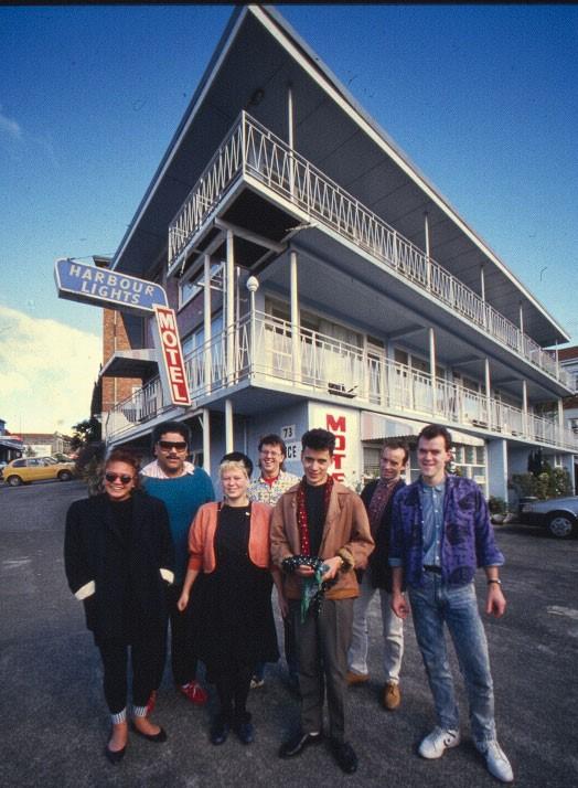 The Holidaymakers check out the Harbour Lights Motel, Parnell, 1988. From left: Mara Finau, Pati Umaga, Barbara Griffin, Richard Caigou, Peter Marshall, Stephen Jessup, and Andrew Clouston.