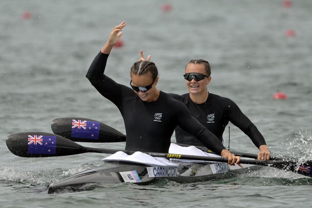 New Zealand's gold medallists Lisa Carrington and Alicia Hoskin celebrate their victory in the women's kayak double 500m final of the canoe sprint competition at Vaires-sur-Marne Nautical Stadium in Vaires-sur-Marne during the Paris 2024 Olympic Games on August 9, 2024. (Photo by Bertrand GUAY / AFP)