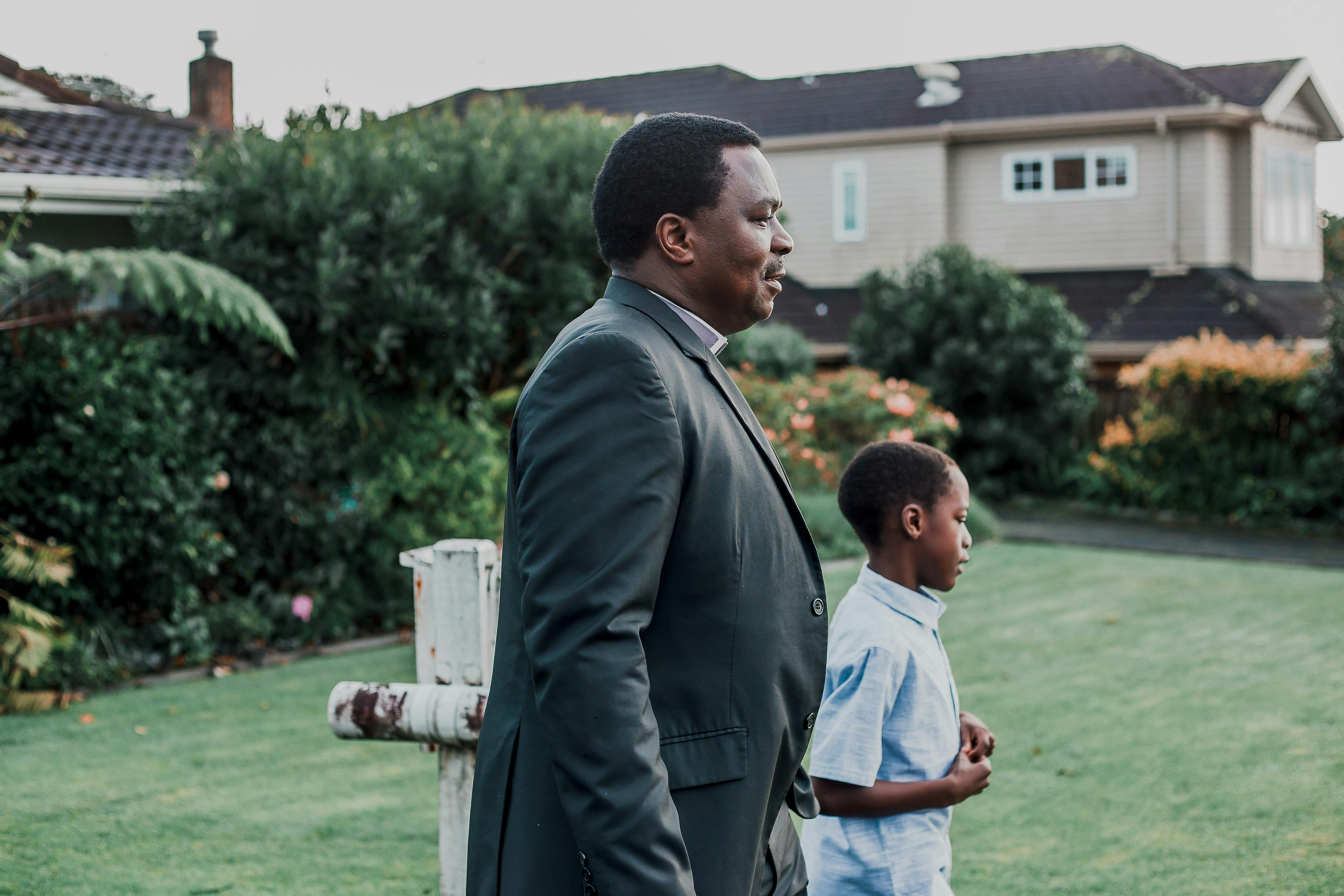 (L-R) Amos Muzondiwa and his son Ben walk to church in Ōwairaka, Auckland.