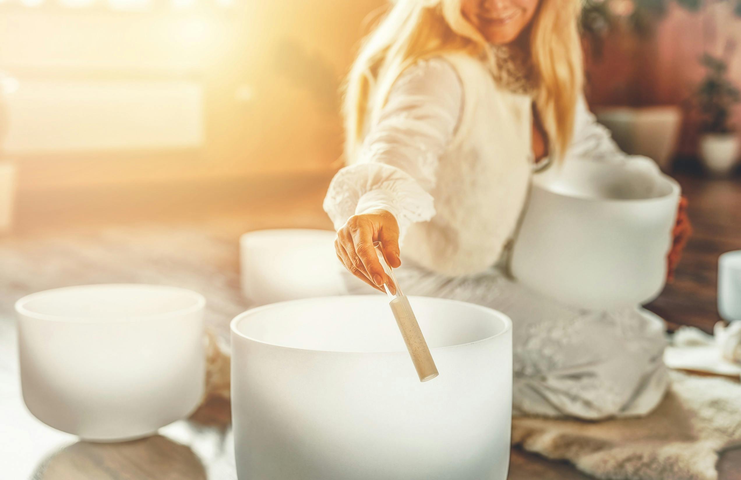 Woman playing on a crystal bowl.