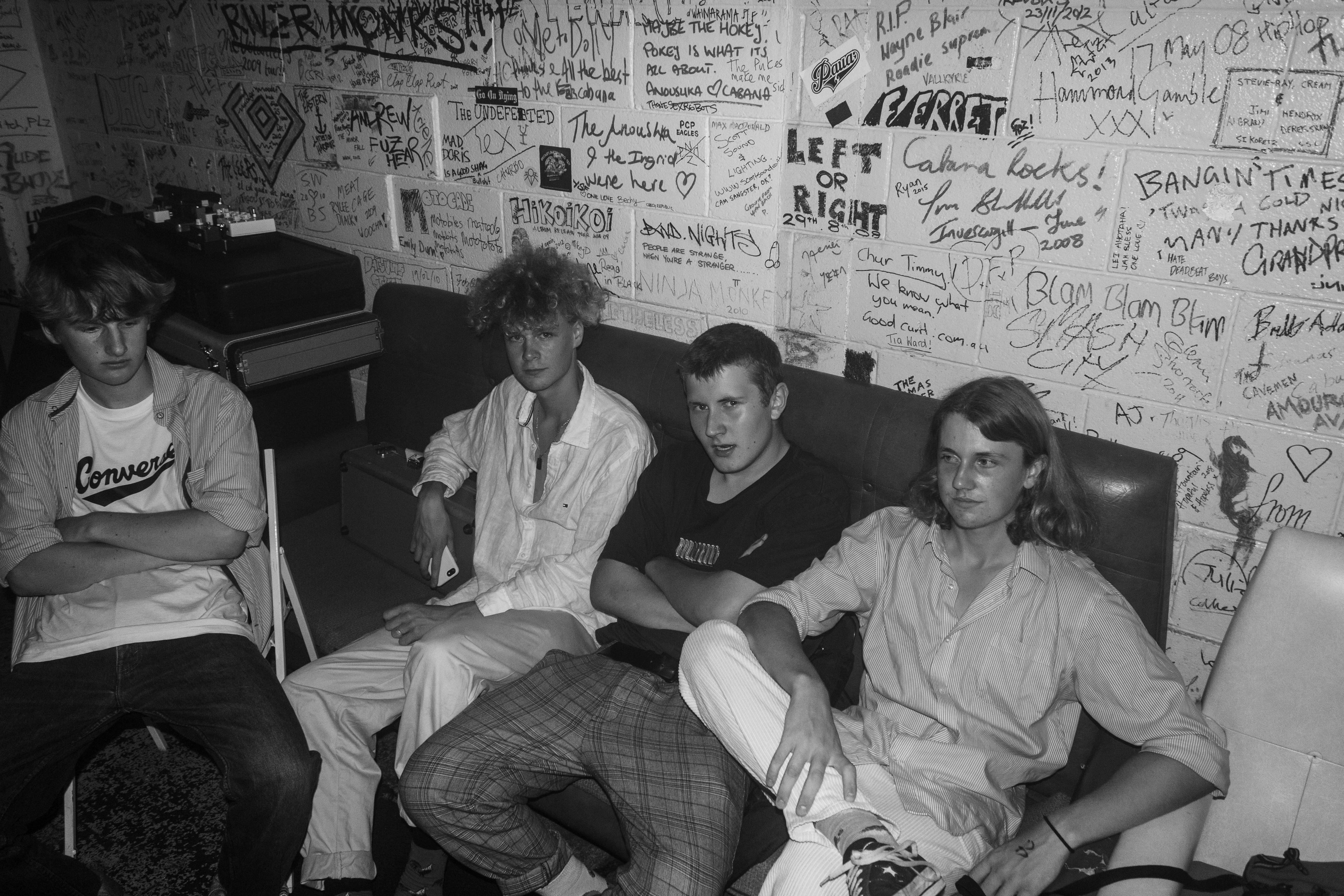 Black and White photo of four young men sitting on a couch