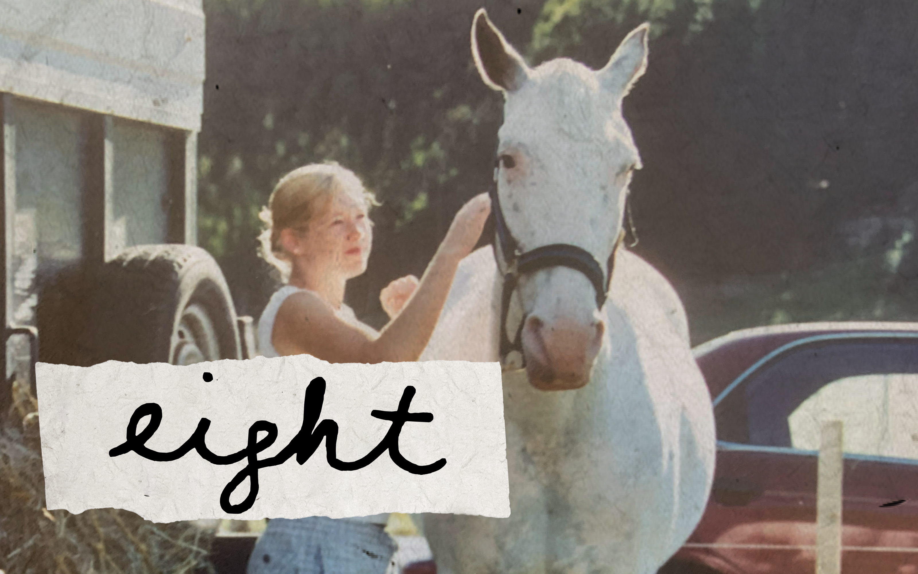 Title "eight" overtop old photograph of a young women patting a white horse