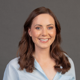 Smiling Gwen McClure with a grey background