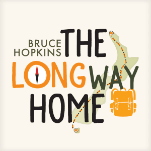 Illustration of the country New Zealand with a dotted walking line from the top of the North Island to Stewart Island. The text in front of this reads "Bruce Hopkins, The Long Way Home". The 'O' in 'Long' is an illustrated compass, and an illustration of a tramping pack sits under the word "Way".