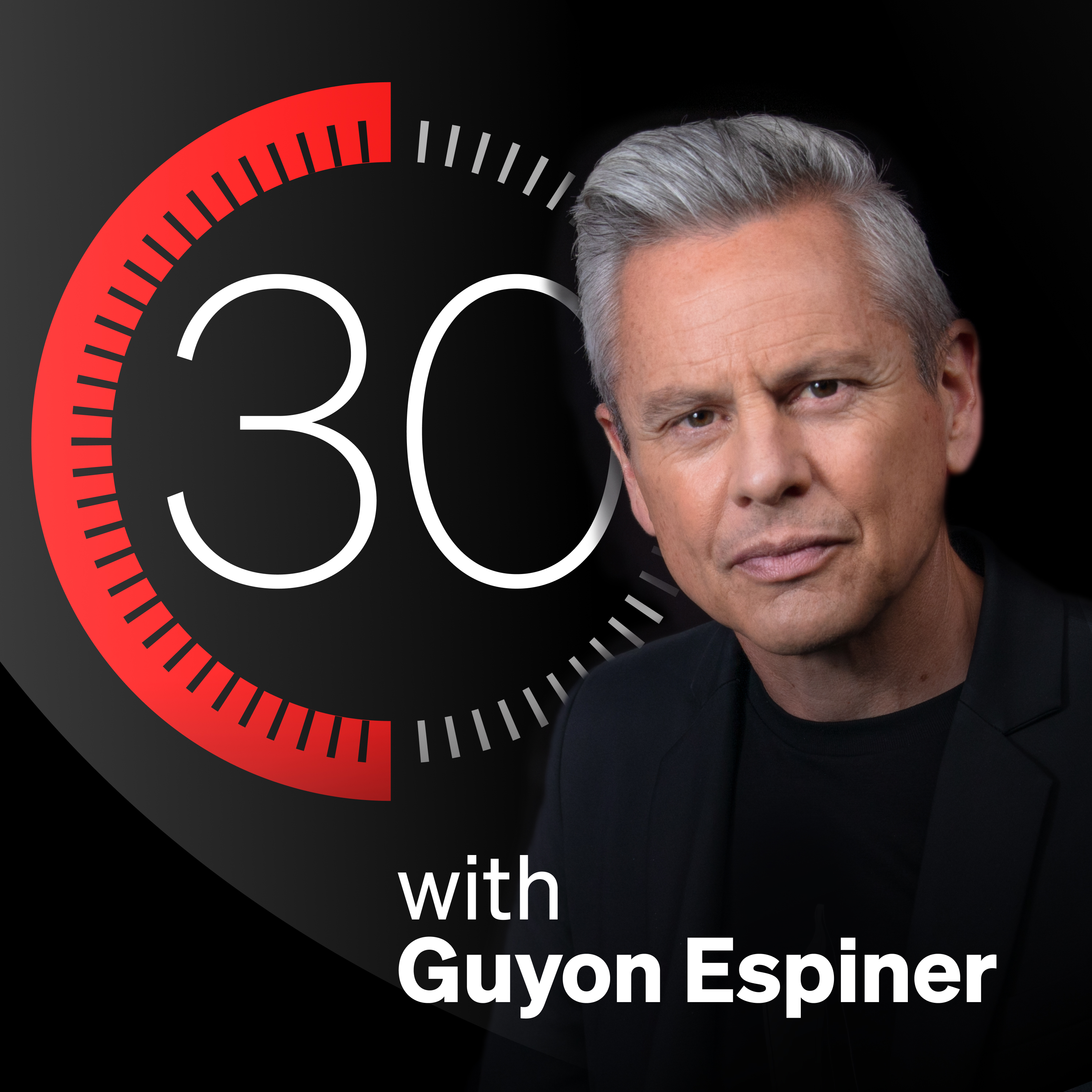 Guyon Espiner on a black background, looking at camera with logo behind him