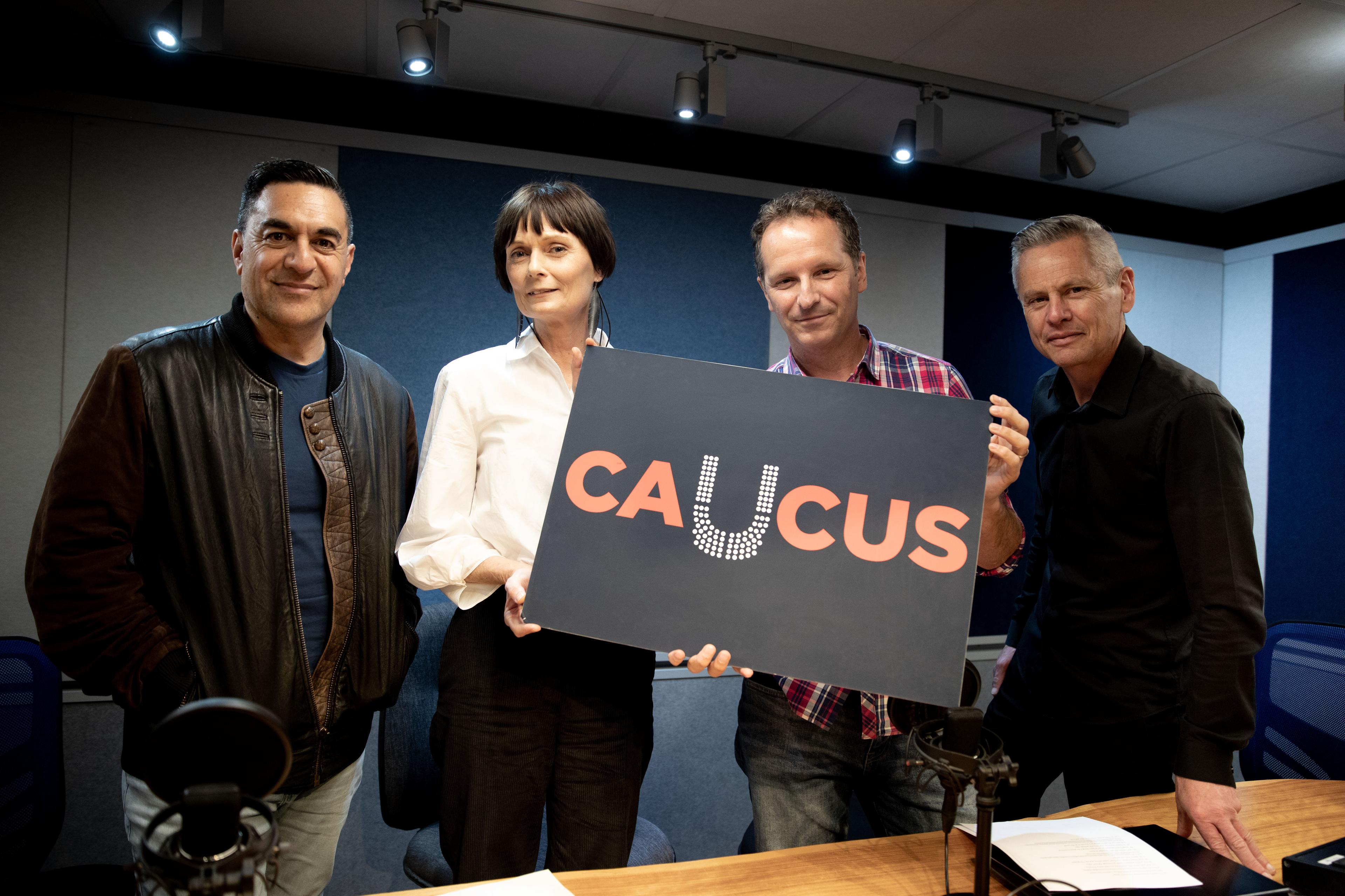 Julian Wilcox, Lisa Owen, Tim Watkin and Guyon Espiner. Lisa and Tim hold a sign for their election podcast Caucus.