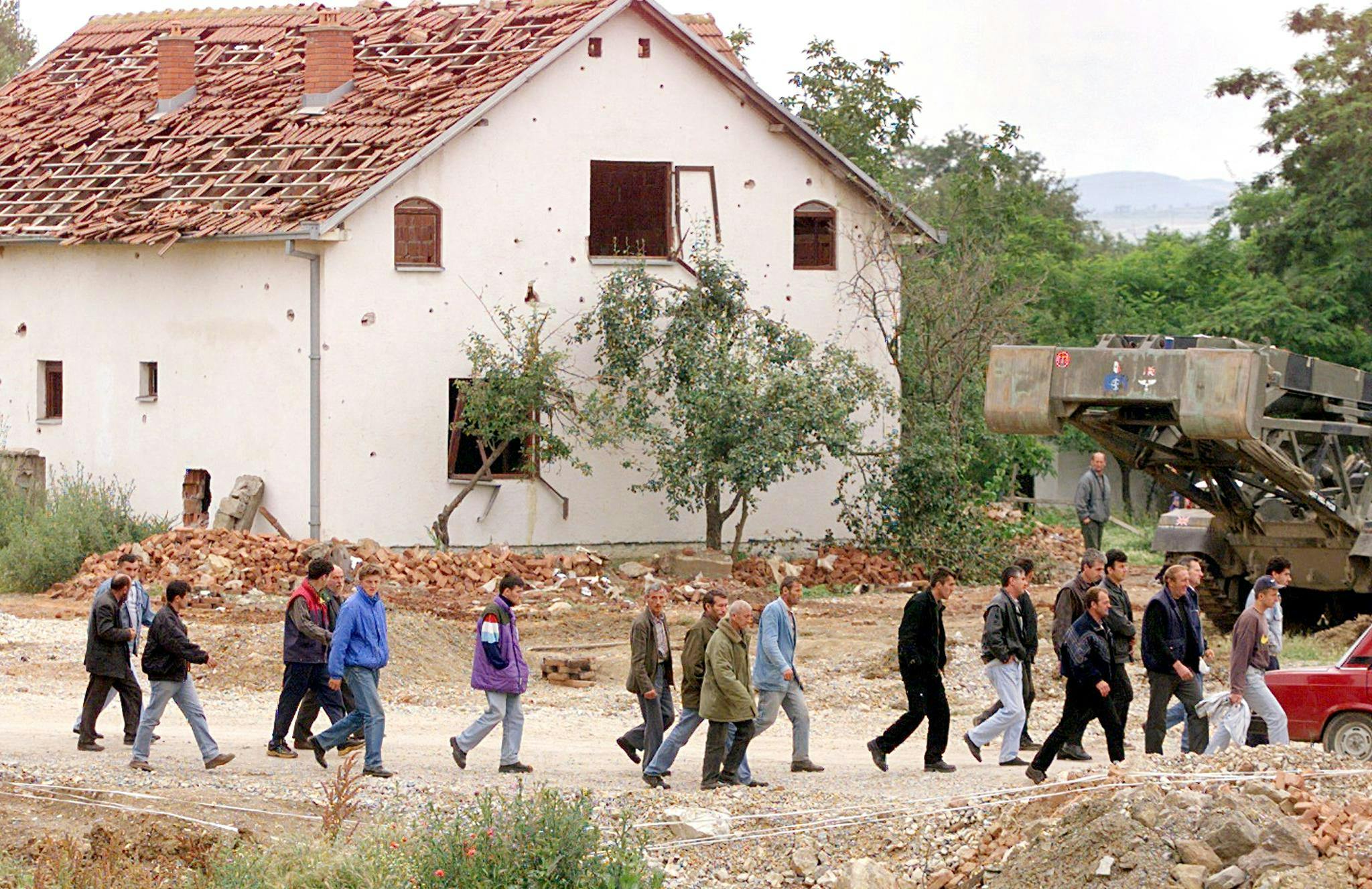 Ethnic Albanian Kosovars walk 25 June 1999 on their way back home on a road between Pristina and Mitrovica, after spending three months in refugee camps in Macedonia. The UN refugee agency and NATO were gearing up for the organised return to Kosovo of thousands of ethnic Albanians after being caught off-guard by the return of refugees under their own steam. (ELECTRONIC IMAGE) (Photo by JEAN-PHILIPPE KSIAZEK / AFP)