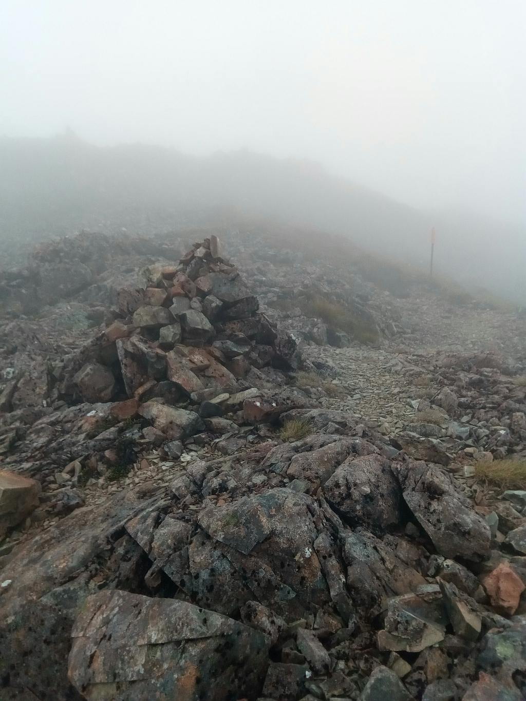 An image of a rock cairn, high on a ridge line, very useful for identifying the trail.