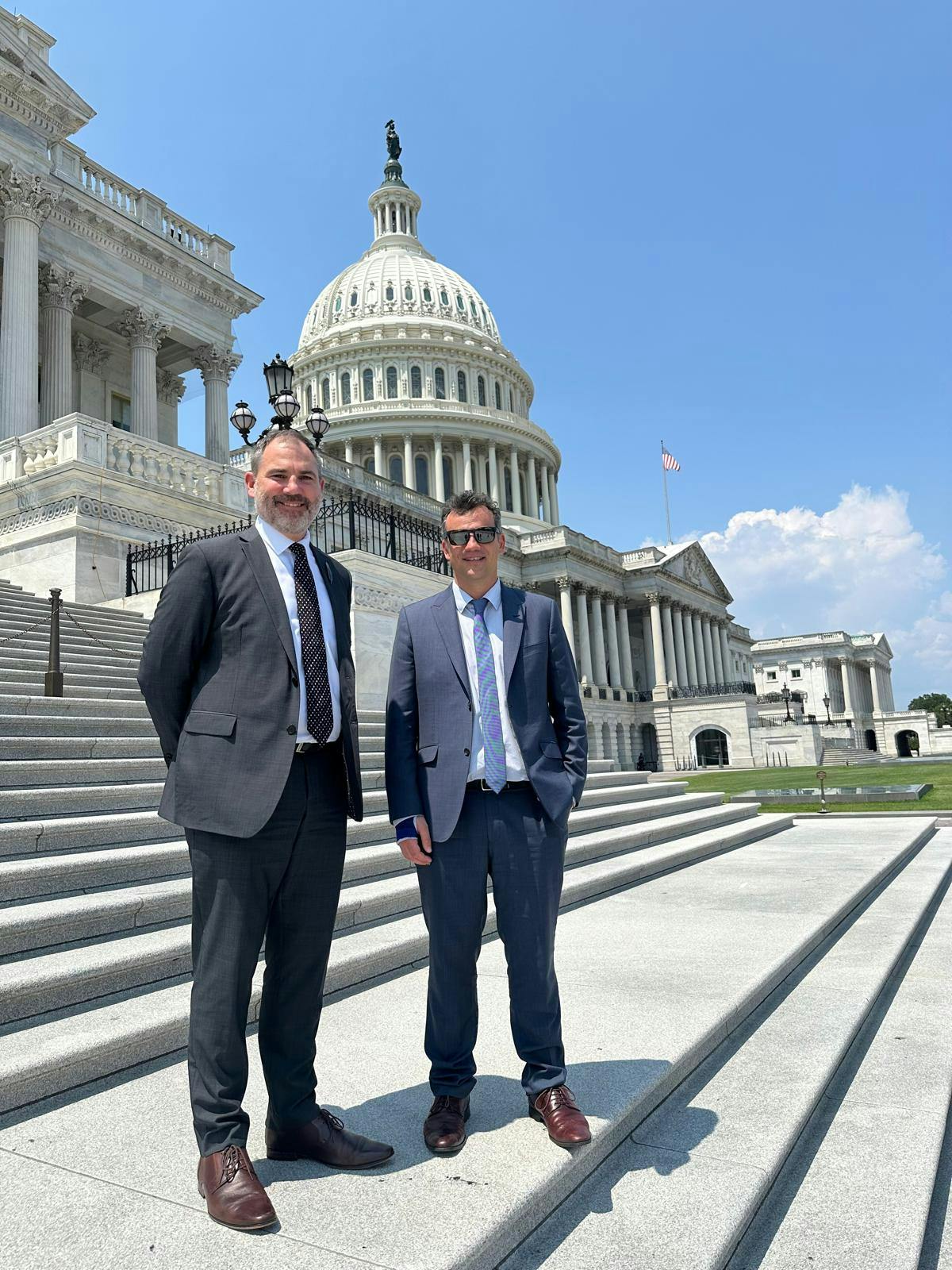 Two MPs pose for a photo in front of the Capitol building in Washington D.C.