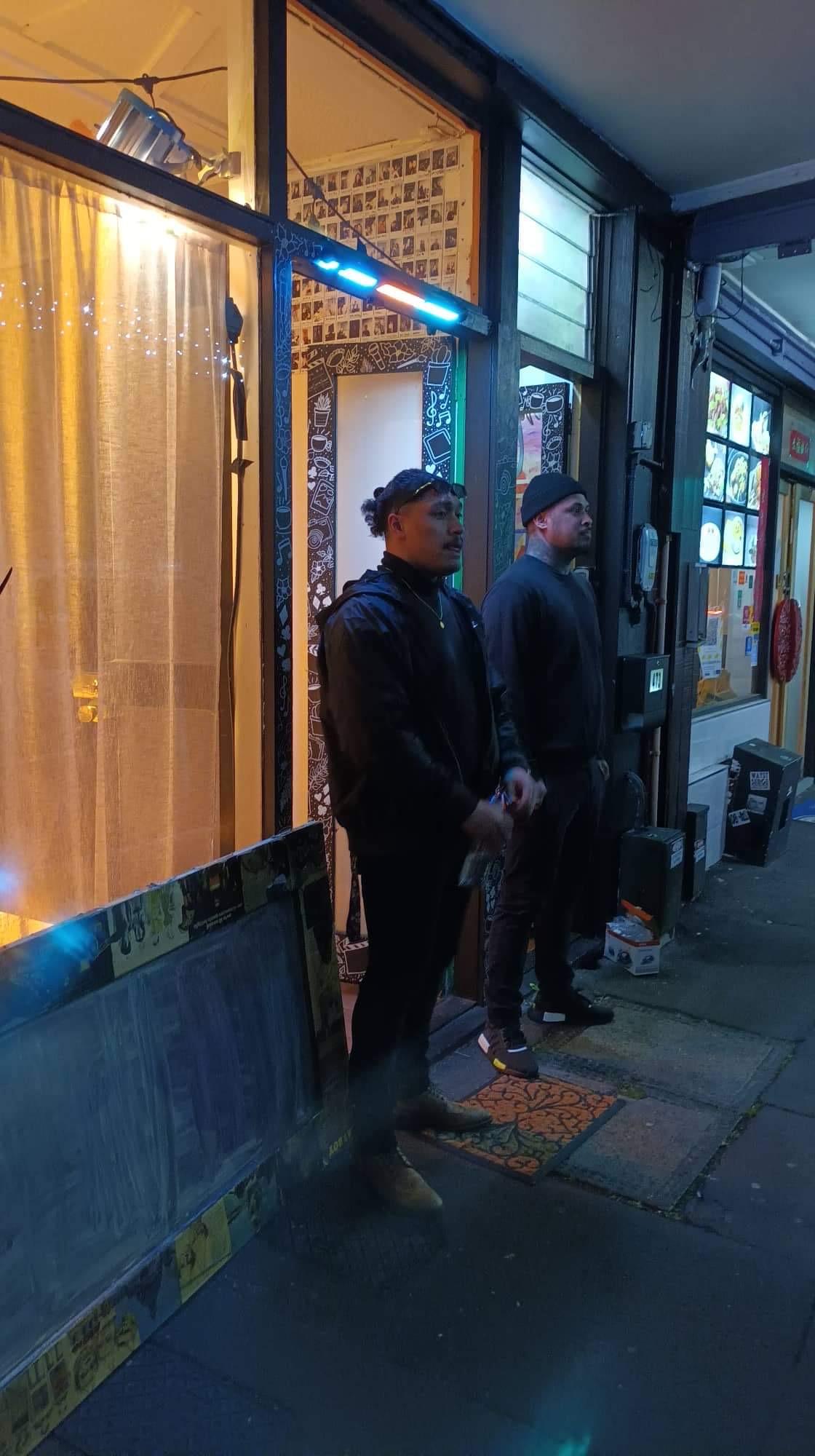 An image of two bouncers standing outside a venue.