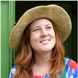 Kate Evans smiling wearing a wide brimmed sun hat.