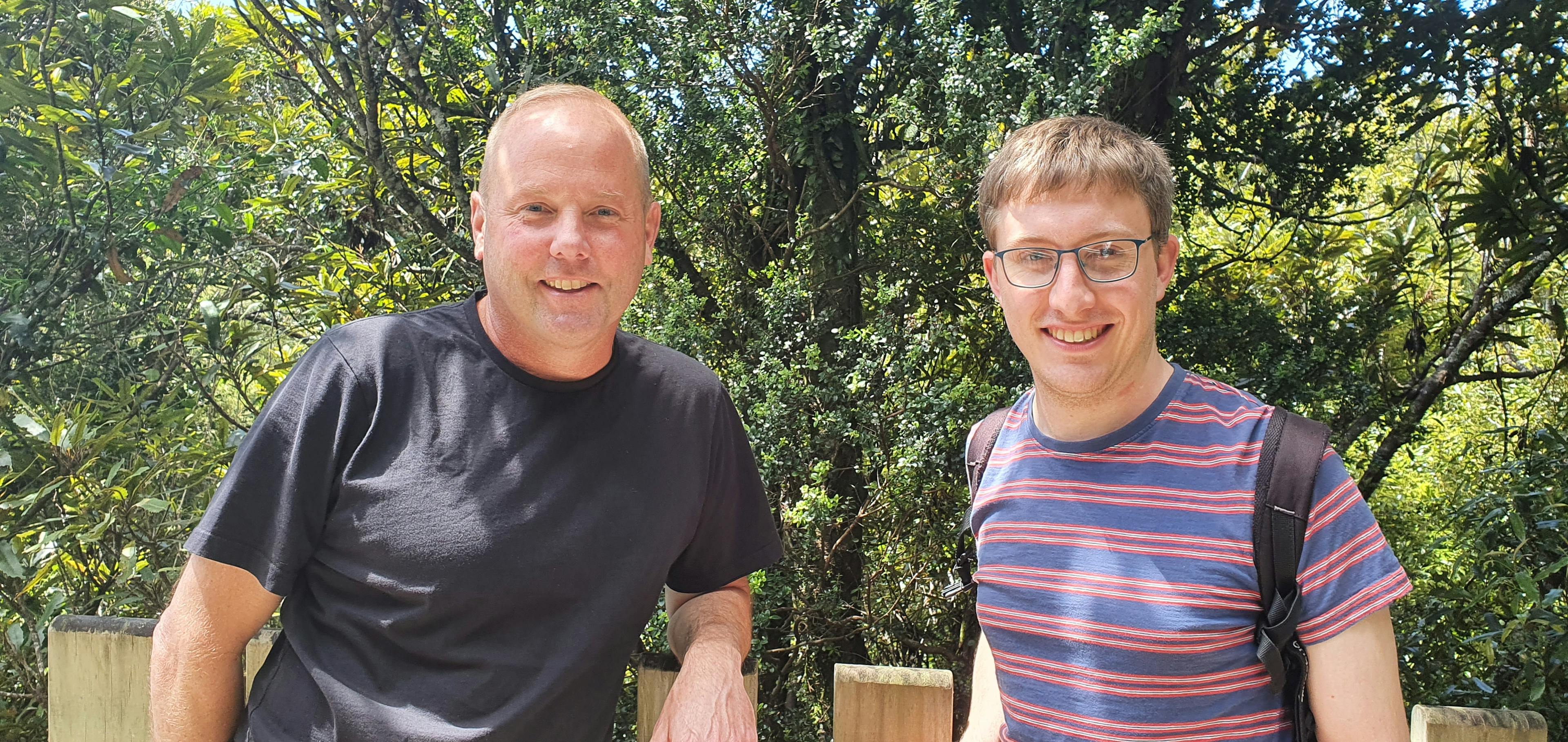 Ecologists with an interest in epiphytes: KC Burns and Tom Dawes stand in front of a climbing rata growing up a larger tree.