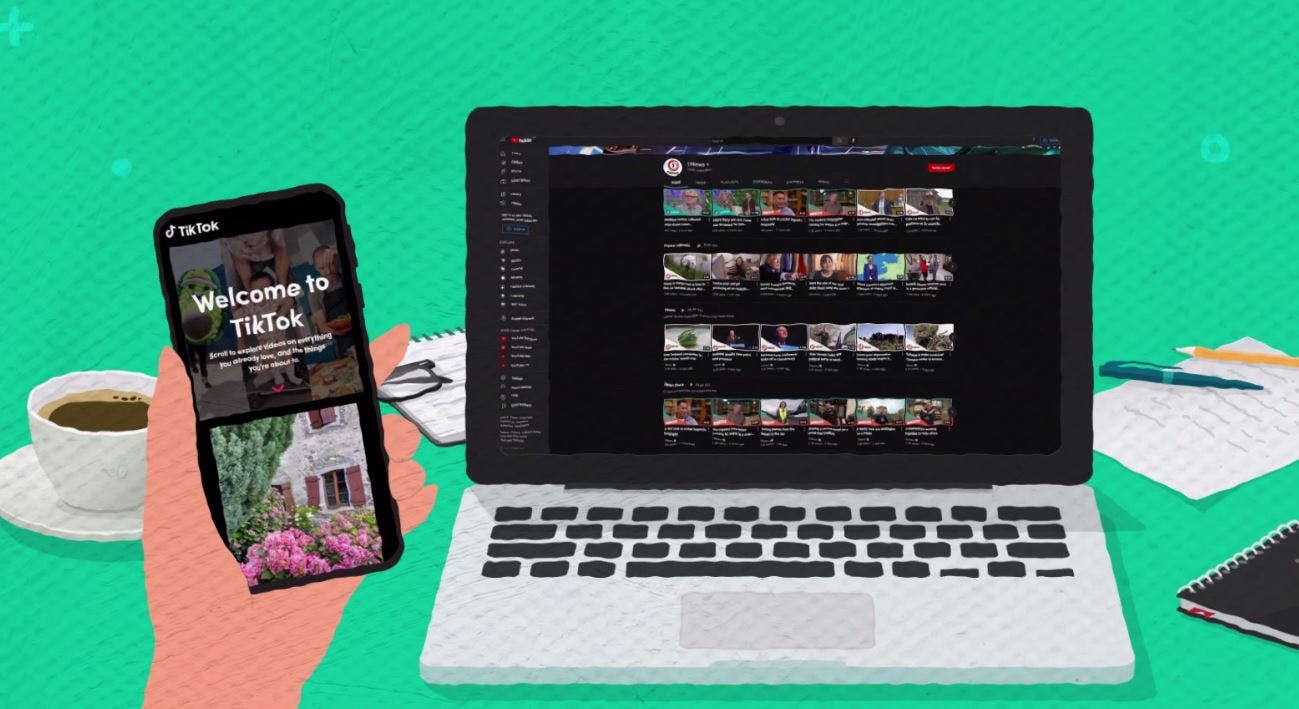 A laptop sits on a table next to a cup of coffee. The screen shows internet videos from TVNZ. A hand holds up a smartphone open to the app TikTok.