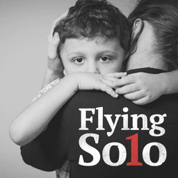 A black and white image featuring a little boy looking at the camera being held by his mum. The text reads "Flying solo".